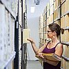 uni-assist Mitarbeiterin sortiert Akten ins Archiv ein.