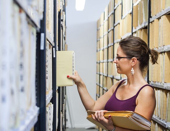 uni-assist Mitarbeiterin sortiert Akten ins Archiv ein.